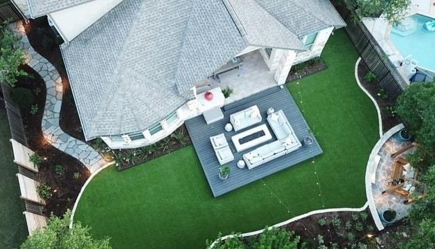 Aerial of a Bee Cave backyard with a deck, turf, and flagstone patio
