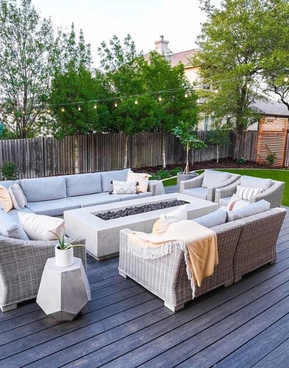 Fire table, turf, and planters set against the cedar privacy screen