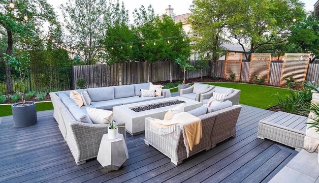 Composite deck with a firepit, turf, and privacy screen in a Bee Cave backyard