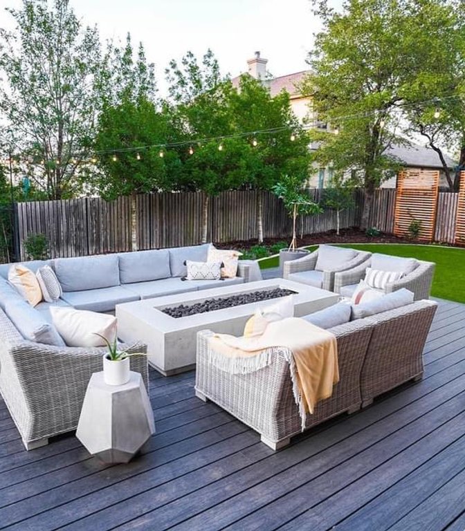 Fire pit on a deck with turf, planters, and a privacy screen at a Bee Cave backyard