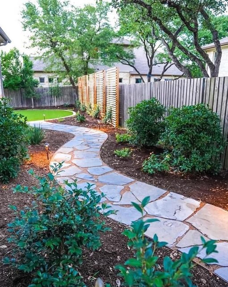 Finished flagstone pathway winding through planting beds at a Bee Cave landscape