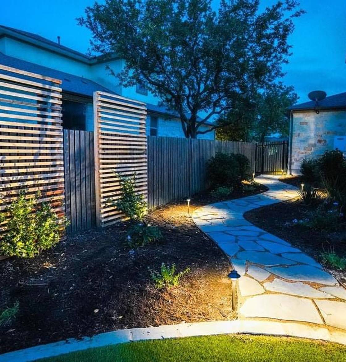 Bee Cave home with stone walkway, native plantings, and landscape lighting