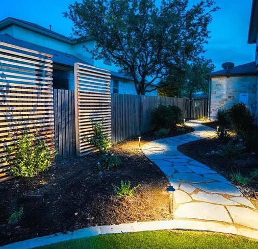 Accent lighting along a flagstone pathway and privacy screens in Bee Cave