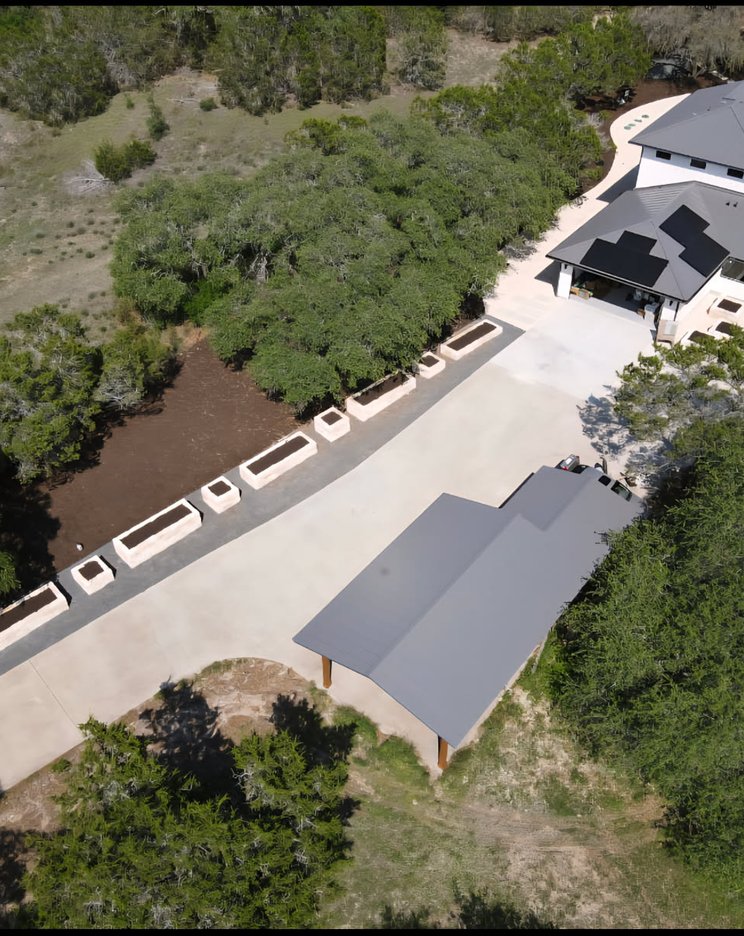 Aerial view of a Driftwood landscape with raised stone beds along the driveway