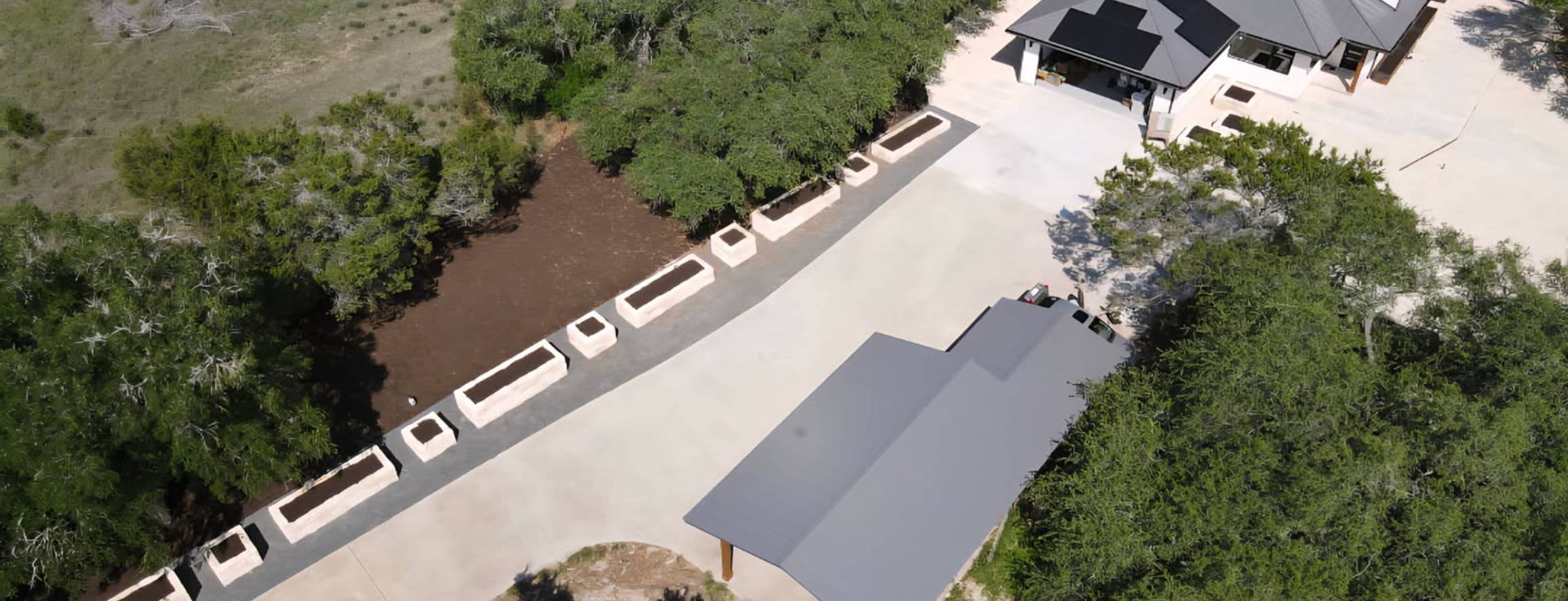 Driftwood garden estate with raised limestone beds and a circular garden, aerial view, by Thrive Landscape and Design