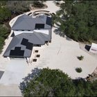 Aerial view of a designed Hill Country estate landscape in Driftwood with stone raised beds, paver walkways, and planting laid out to a master plan