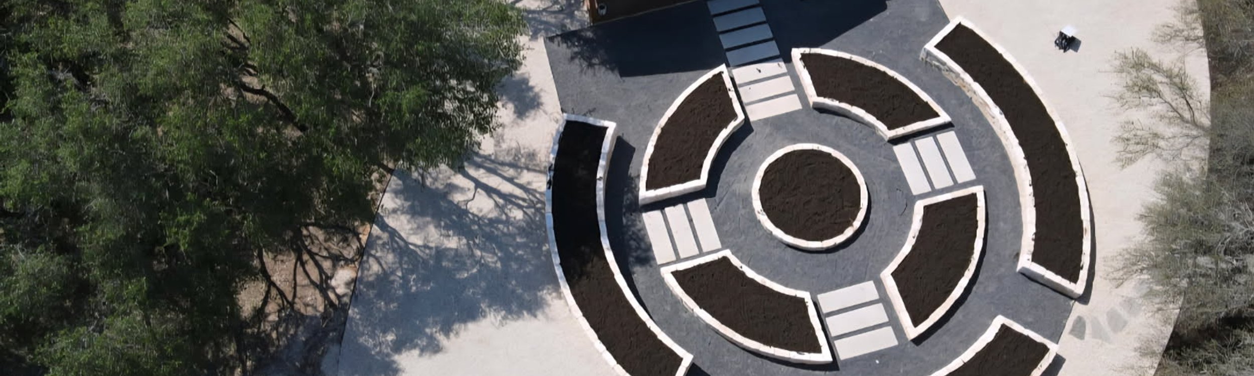 Aerial view of a completed Driftwood landscape design with raised stone beds and paver pathways
