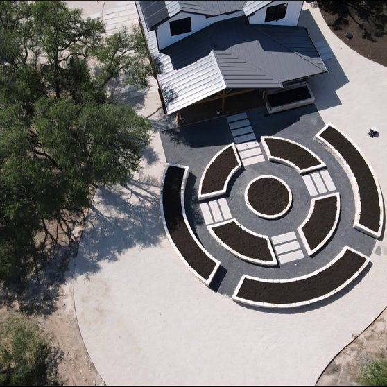 Aerial view of a Driftwood yard with raised beds and pavers shaping water flow around the home