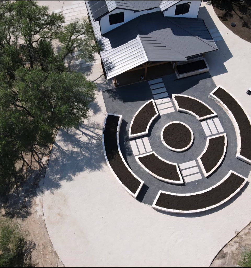 Aerial view of a Driftwood estate with raised limestone beds and paver paths that grade water away from the structures