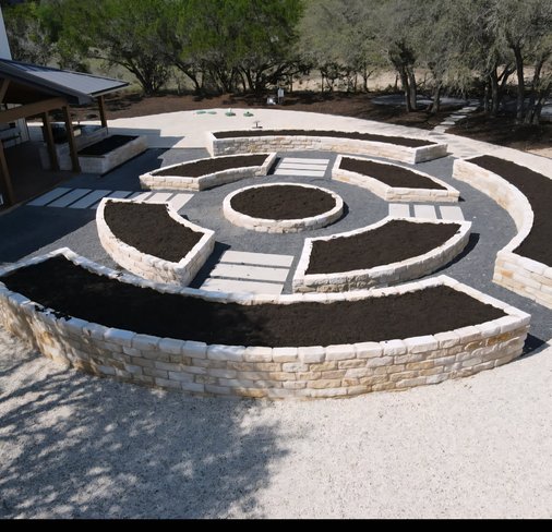Detail of a stone paver walkway with crisp edges between raised beds at a Driftwood estate