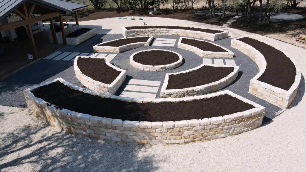 Phase one install at a Driftwood acreage property with raised beds and a stone paver walkway