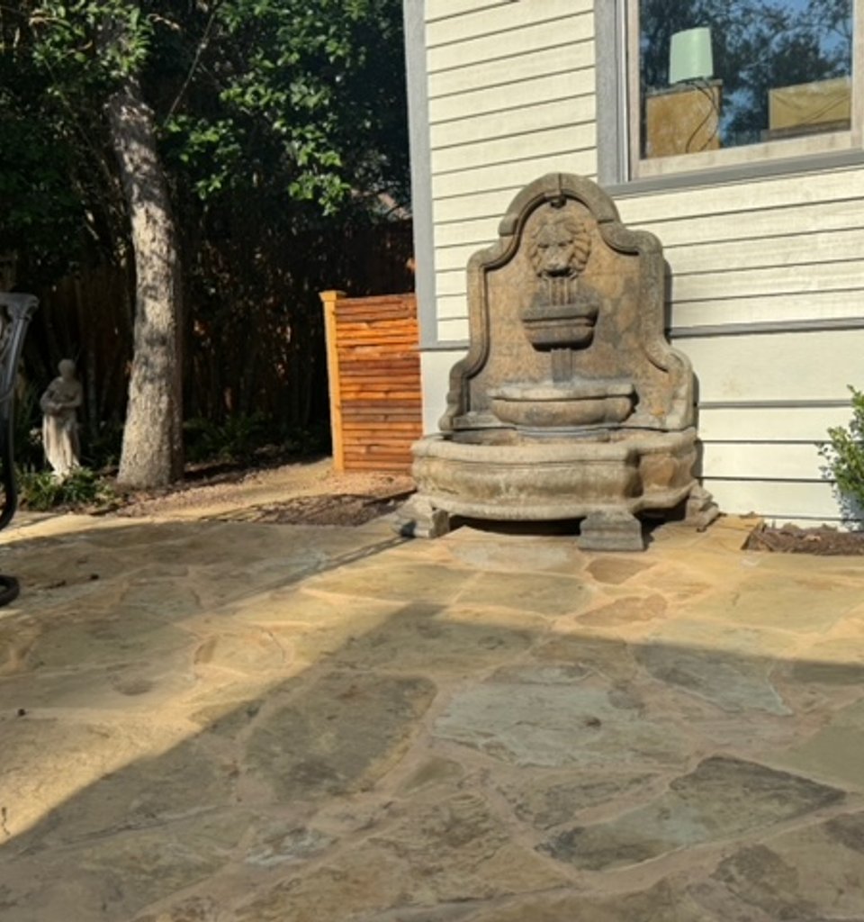 Garden-district-style flagstone patio with a fountain and iron furniture
