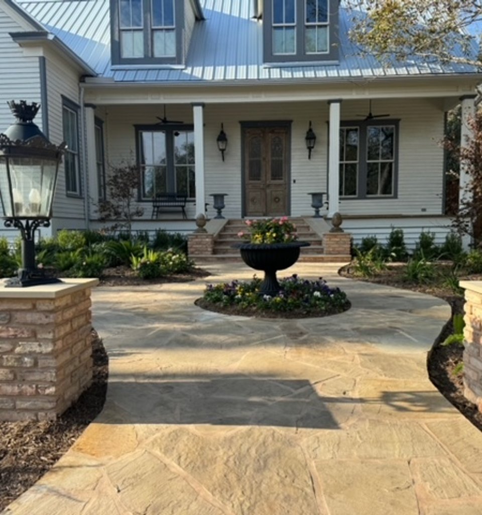 Fayetteville garden with a flagstone walkway, brick columns, and stone urns