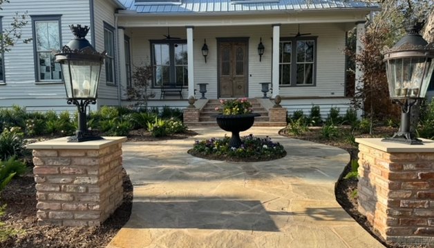 Flagstone walkway flanked by brick columns and urns at a Fayetteville home