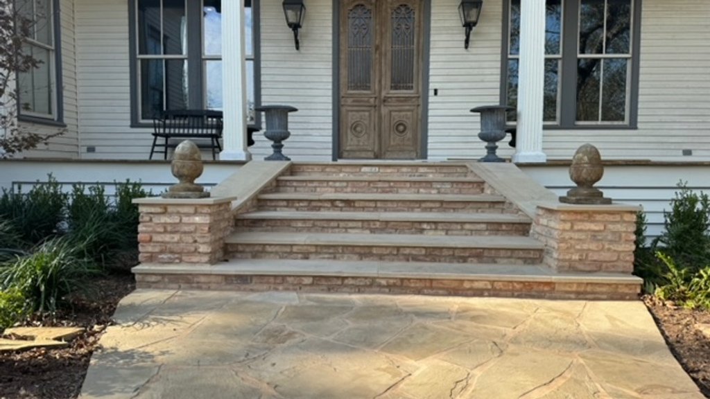 Low-voltage path lighting routed along a flagstone walkway and brick steps in Fayetteville