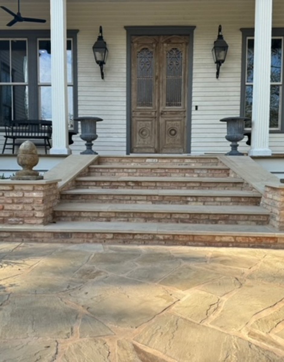 Flagstone walkway meeting brick steps to the front porch