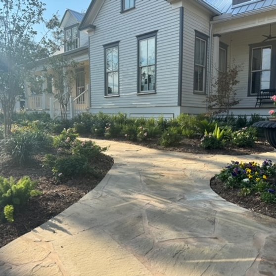 Garden beds framing a flagstone walkway in a Central Texas garden