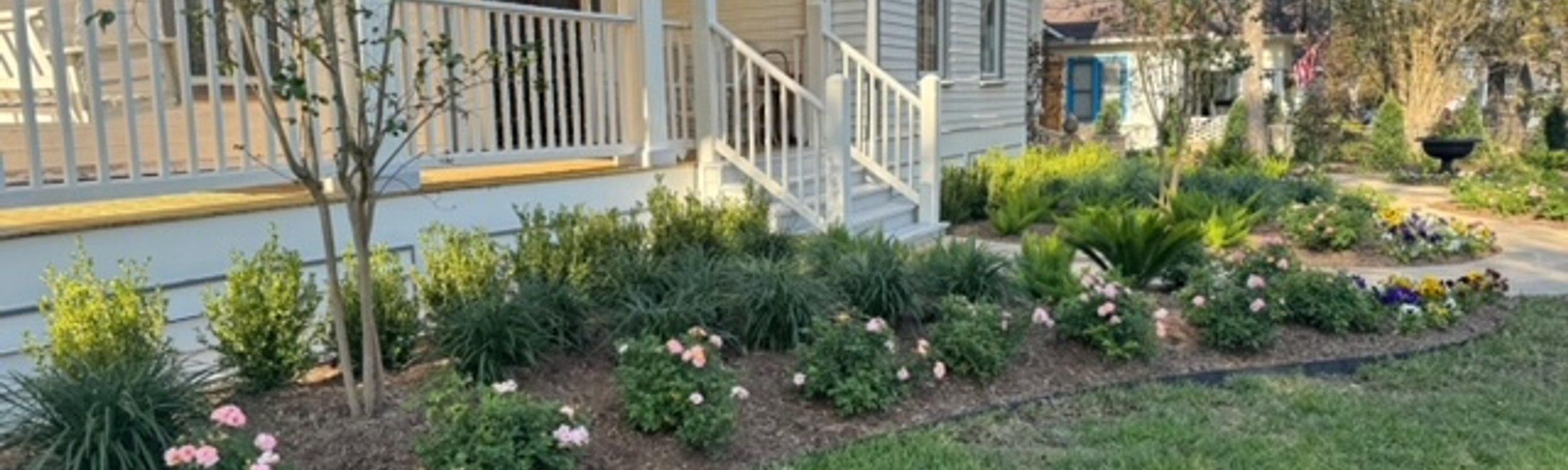 Freshly mulched flower beds bordering a green lawn at a Central Texas home