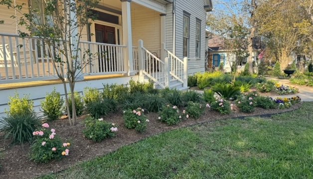 Newly planted flower beds and lawn in a Fayetteville landscaping install