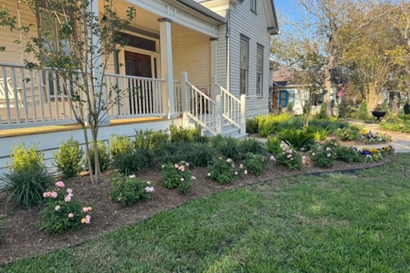 Layered flower beds and a healthy lawn in a Central Texas garden
