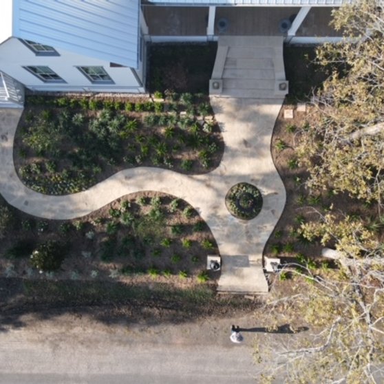 Aerial site overview of a custom home with flagstone walkway and garden beds