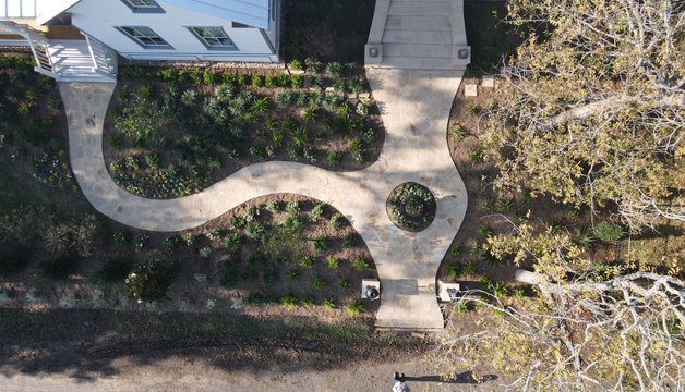 Custom landscape design with flagstone walkway and layered garden beds