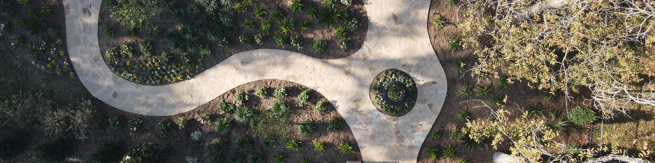 Aerial view of layered garden beds and stone walkways in a Central Texas landscape