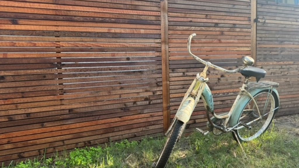 Stained cedar privacy fence after final walk-through along a Fayetteville lawn