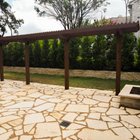 Cedar pergola shading a flagstone patio and fire pit in a Lakeway backyard near Austin