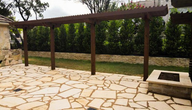 Custom deck and pergola over a flagstone patio and fire pit in Lakeway