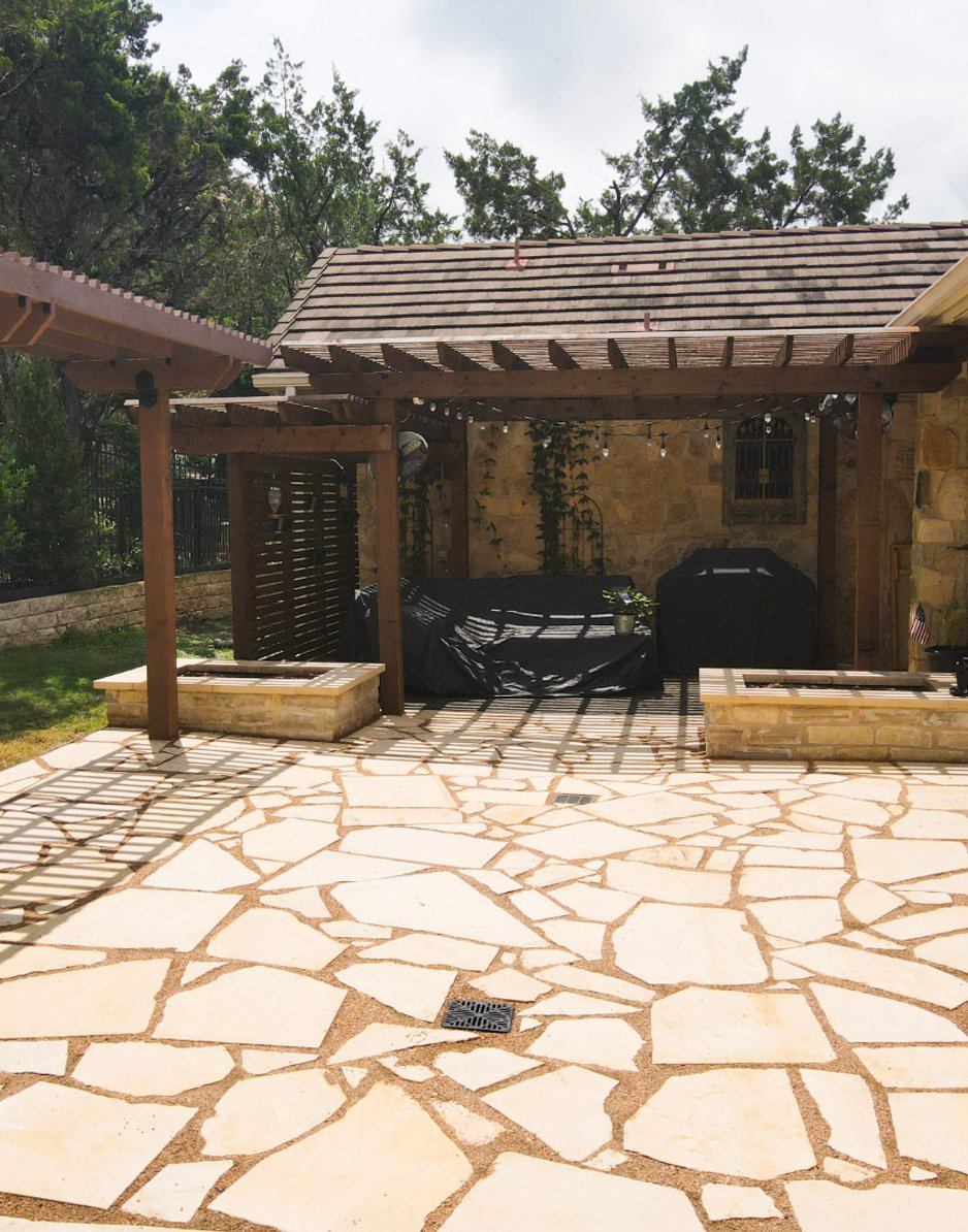Built-in limestone raised planting beds flanking the grill station