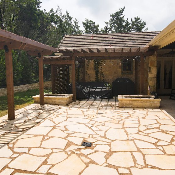 Lakeway backyard with a pergola, flagstone patio, and stone planters