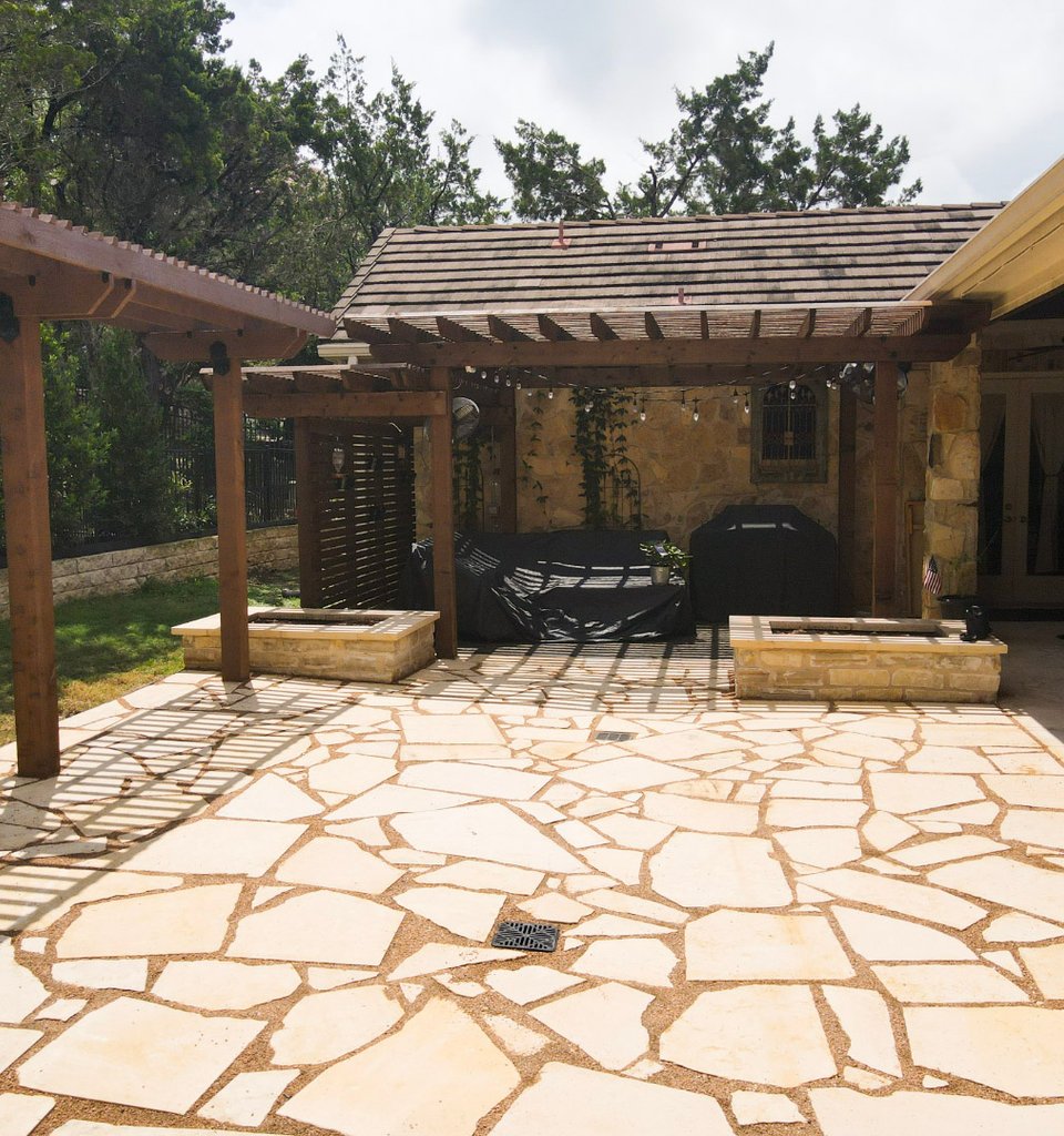 Lakeway flagstone patio with a pergola and stacked-stone planter walls