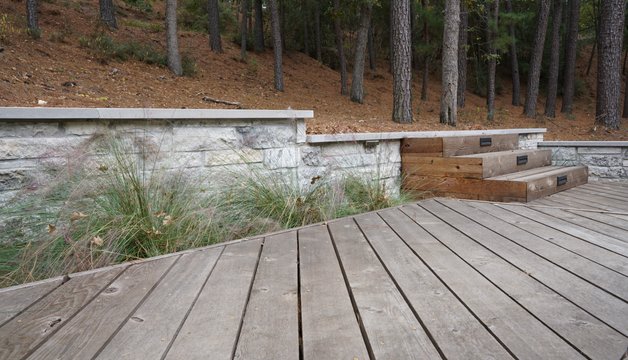 Multi-level deck stepping down to a retaining wall on a Lost-Pines slope