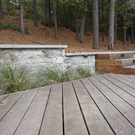 Composite deck with steps down to a retaining wall on a Lost-Pines lot