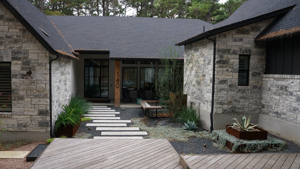 Custom deck design with pavers and planters realized on a Lost-Pines lot