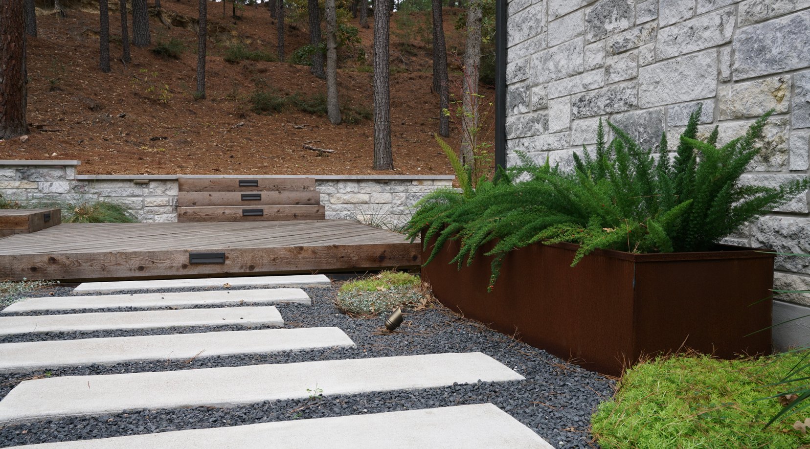 Pavers, gravel, and planters leading toward the rear deck