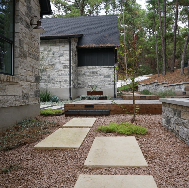 Paver patio and retaining wall with a drought-tolerant xeriscape in the Bastrop Lost Pines