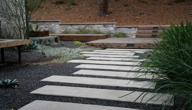Paver walkway, stone retaining wall, and deck on a Lost-Pines property near Austin