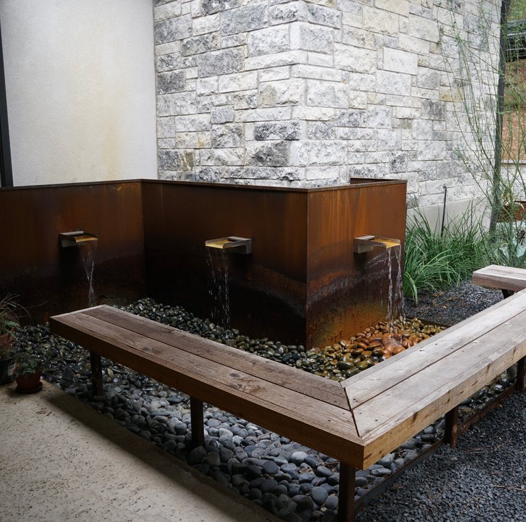 Corten-steel water feature and bench seating in a Bastrop Lost Pines courtyard