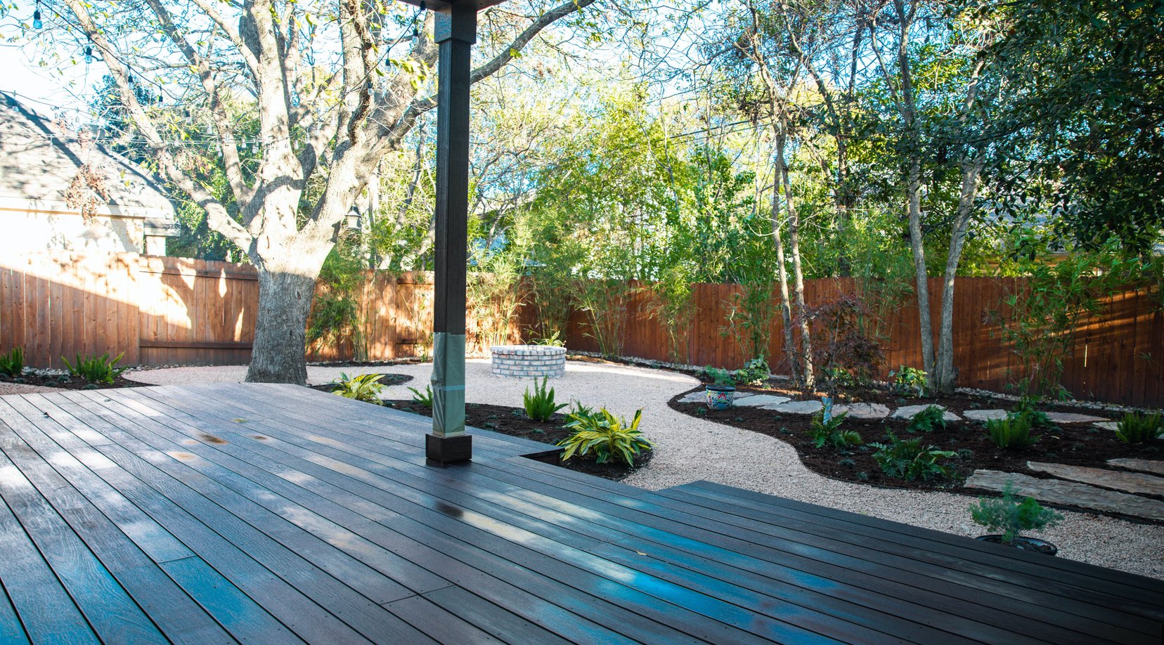 Deck and fire pit with decomposed granite paths and layered shade planting beds