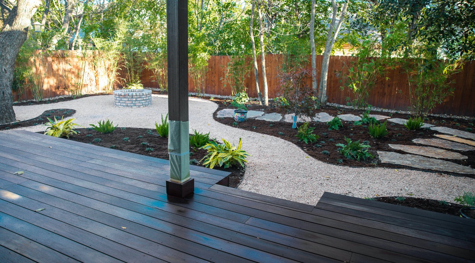Dark stained deck meeting flagstone and decomposed granite at the fire pit