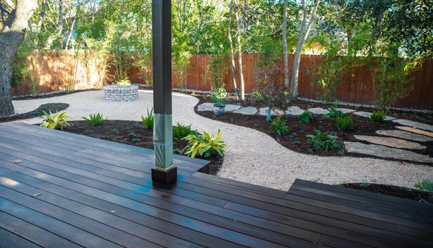 Stone fire pit set into a flagstone patio in a Riverplace, Austin backyard