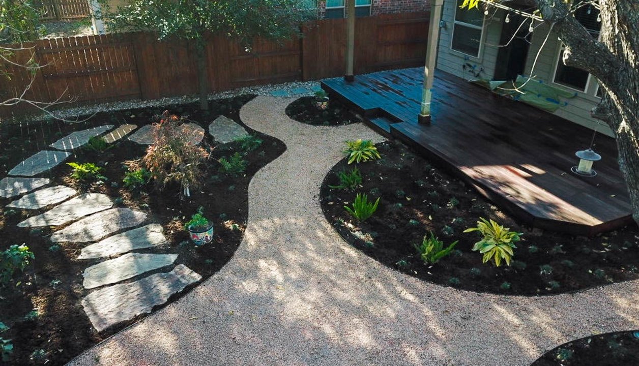Wood deck with a flagstone pathway in a shaded Riverplace garden