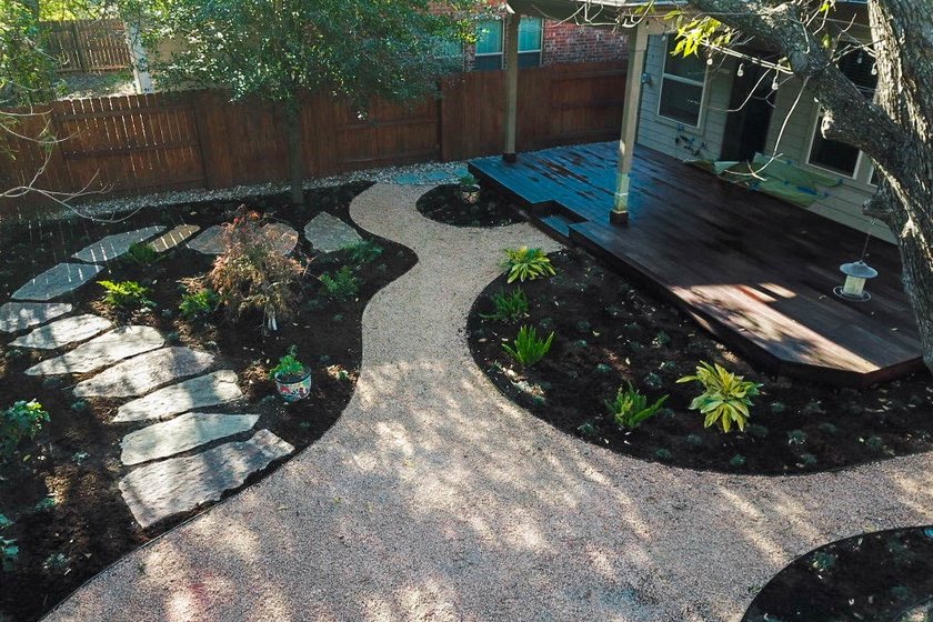 Austin backyard in the River Place neighborhood with a flagstone pathway, decomposed granite, a fire pit, and native planting beds