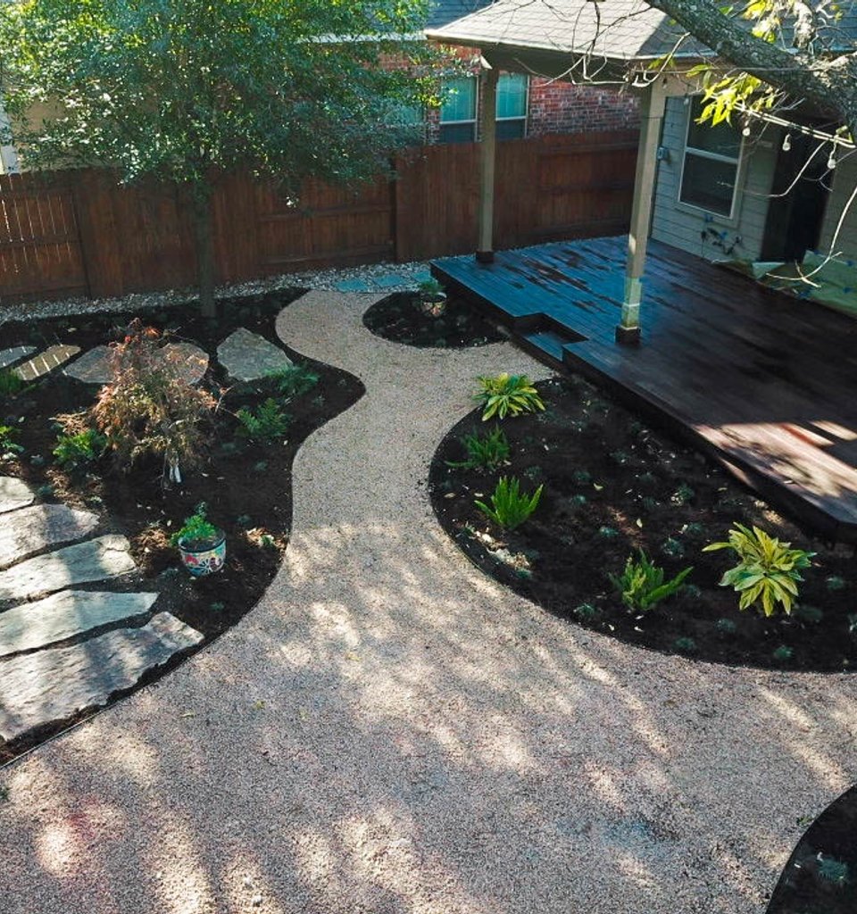 Riverplace shaded garden with a deck, flagstone pathway, and decomposed granite beds