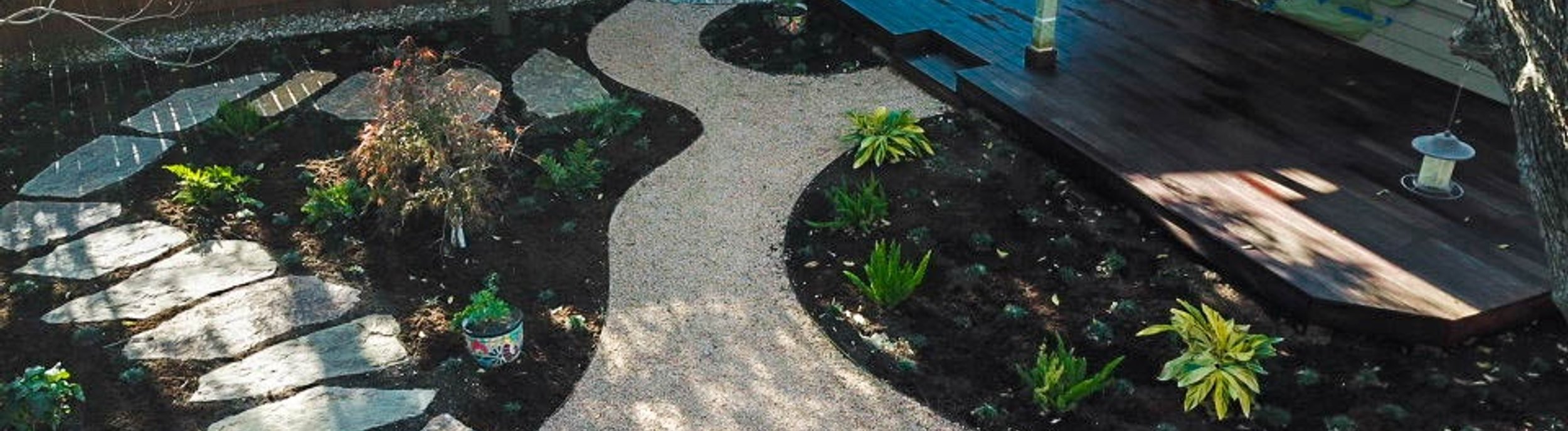 Austin backyard in the River Place neighborhood with a flagstone pathway, decomposed granite, a fire pit, and native planting beds