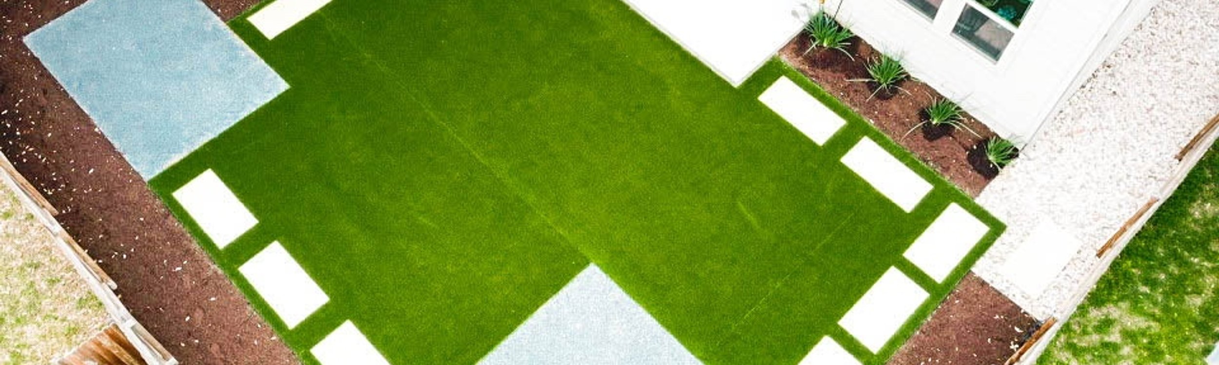 Aerial view of a freshly installed green lawn with stepping stones and planting beds at a Round Rock home