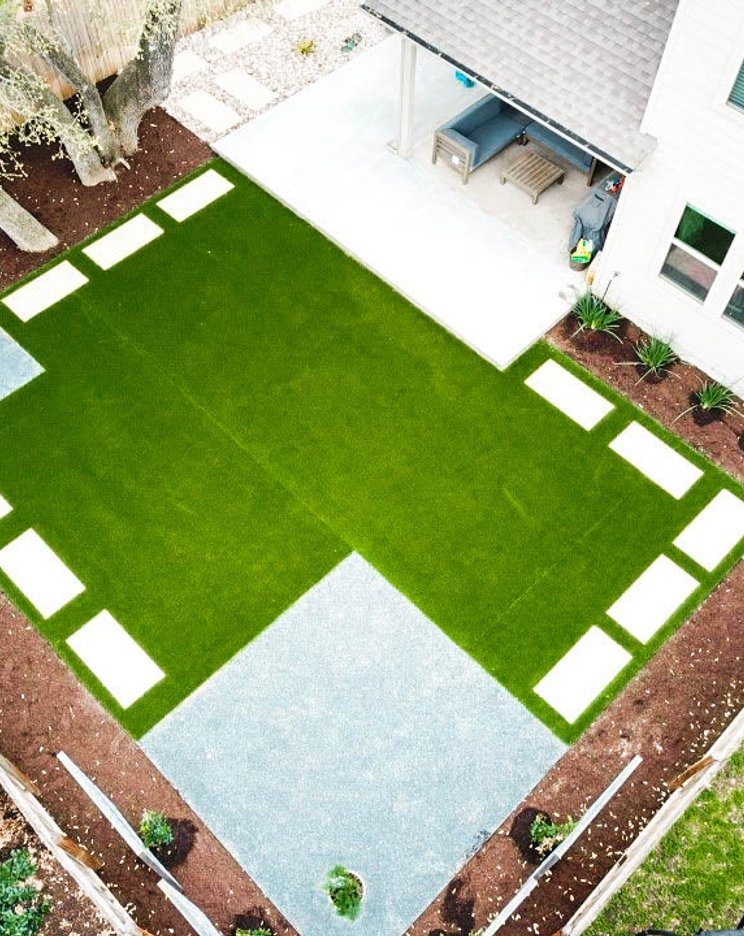 Aerial view of a healthy turf lawn with stepping stones and planting beds in Round Rock