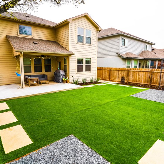 Finished paver patio with turf, stepping stones, and planting beds at a Round Rock home